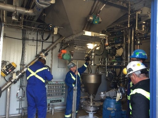 Technicians working on polymer slicing unit out in the field