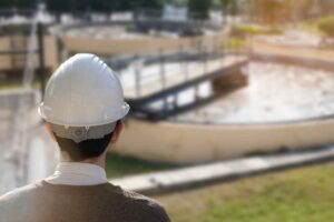 Technician looking out to a water treatment clarifier in the distance