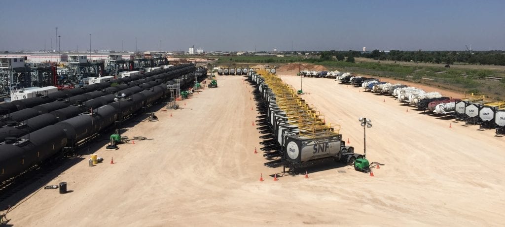 Overhead view of an oil & gas inventory hub with SNF isotainers and railcars 